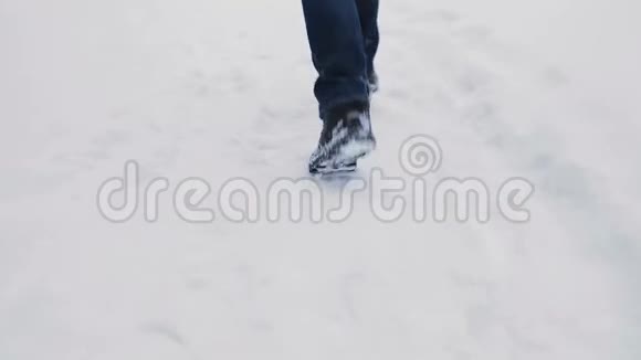 穿着时髦靴子的人在下雪的中央公园跑步下雪了慢动作背面视频的预览图