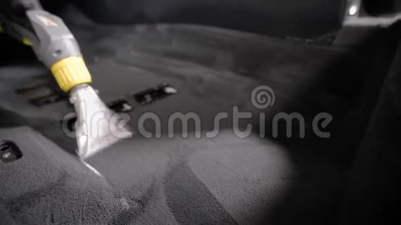 在汽车专业清洗过程中洗车机在车内地毯上使用吸尘器视频的预览图