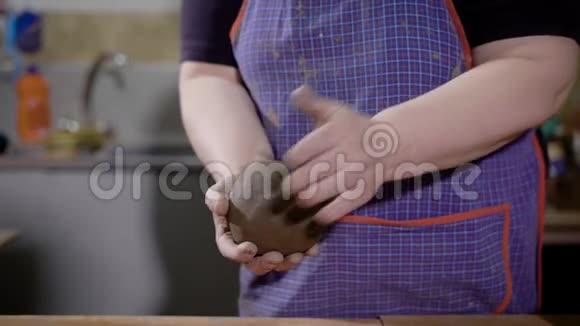 一位女工匠在她手中捏成一块粘土的特写镜头视频的预览图