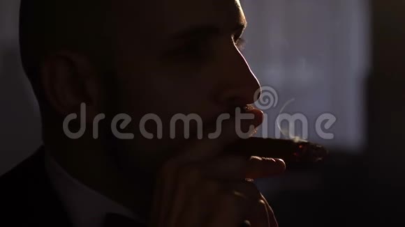 人类在黑暗中用人造光抽雪茄视频的预览图