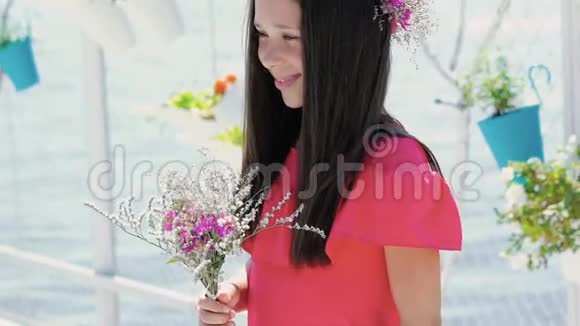 漂亮的年轻女孩站在酒吧湾手里拿着花束慢慢地视频的预览图