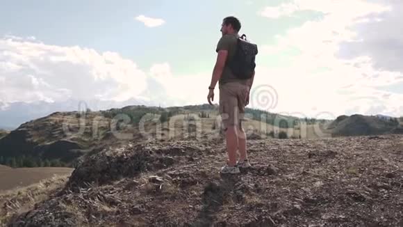 一个带背包游客的人欣赏山景山里的年轻旅行者视频的预览图