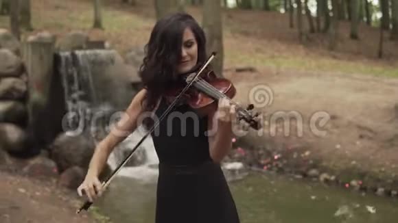漂亮的小提琴手有灵感在森林里拉小提琴的女孩视频的预览图