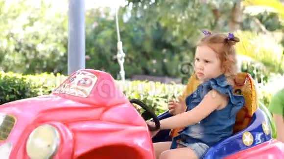 童女在公园里骑电动车娱乐儿童景点视频的预览图