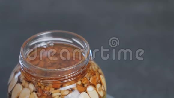用蜂蜜中的坚果旋转开罐特写俯视图视频的预览图