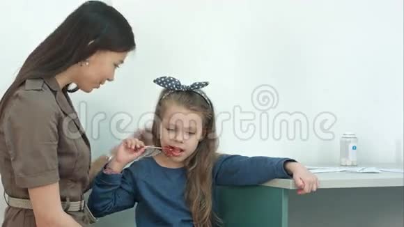 妈妈和她的小女孩在医生办公室吃棒棒糖谈话视频的预览图