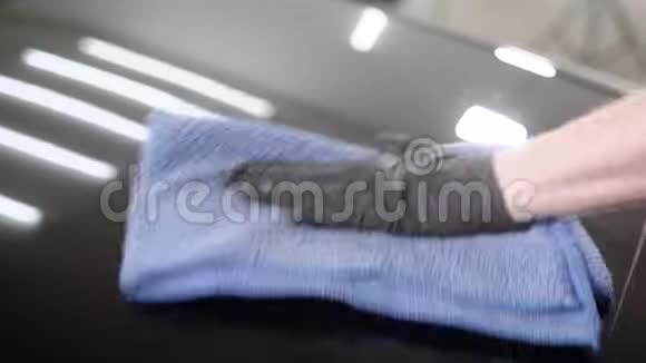 用蓝毛巾近距离观察人手抛光车罩视频的预览图