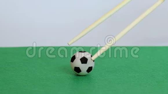 男性用筷子特写中国或日本食物在绿色的田野上举起和放下足球A的概念视频的预览图