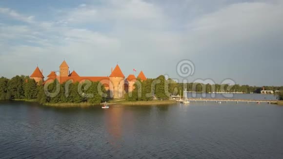 在夏季日落时飞越美丽的特拉凯城堡鸟瞰美丽的城堡在湖泊中视频的预览图