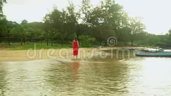 穿着红衣服的女人在海滩上散步越南岛屿沿岸的传统渔船视频的预览图
