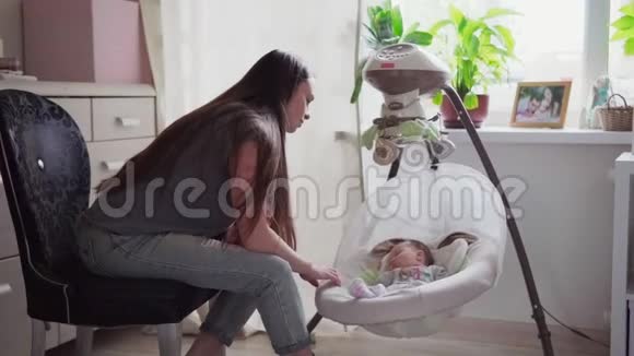 快乐的母亲和婴儿一起摇着摇篮视频的预览图