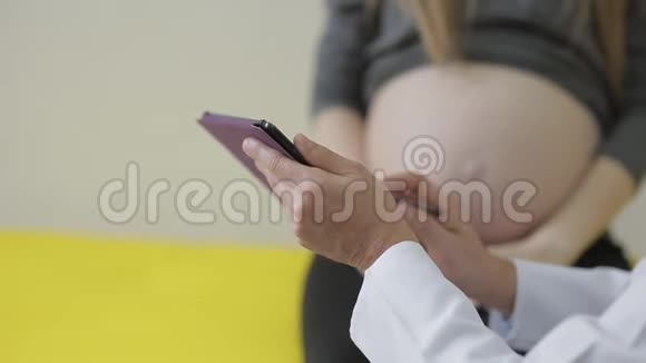 医生在药片上给孕妇看她怀孕的问题特写视频的预览图