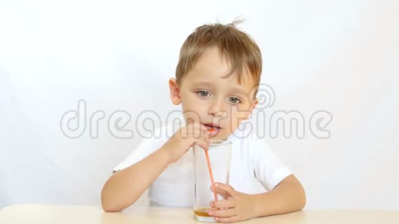 快乐的孩子通过吸管喝果汁坐在桌子旁微笑运动相机滑块视频的预览图