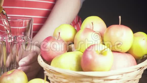 篮子里有苹果女人拿着玻璃杯慢慢地倒果汁视频的预览图