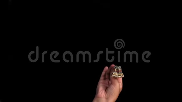 一只女性的手出现显示金色的印度风格的耳环孤立在黑色背景视频的预览图