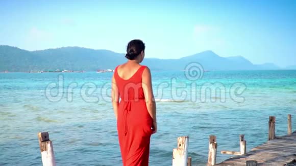 穿着红色长裙走在码头上的美女PhuQuoc岛山海景观女人走过去视频的预览图