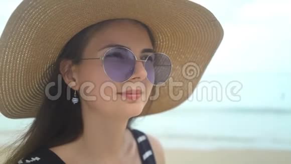 海滩上戴着帽子和太阳镜的美女画像视频的预览图