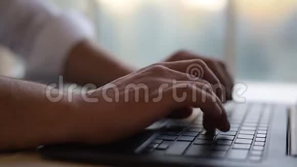 特写镜头男人用手在笔记本电脑键盘上打字视频的预览图