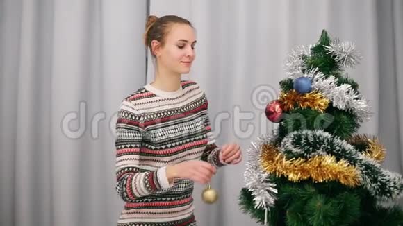 准备圣诞节漂亮的快乐女人坐在人造圣诞树旁在家里装饰它视频的预览图