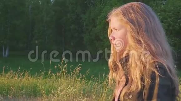 在大自然中一个穿着军服的少女在森林附近的田野上漫步孩子有一头金发视频的预览图