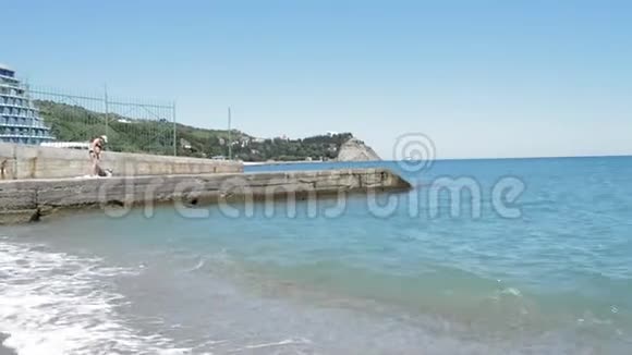 平静的大海伴随着轻柔的海浪一个穿着泳衣的成年女人站在码头上准备游泳视频的预览图