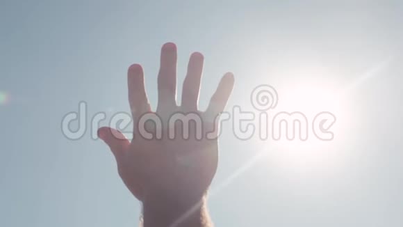 伸出手去晒太阳库存明亮的阳光透过伸出的手伸向天空的手指视频的预览图