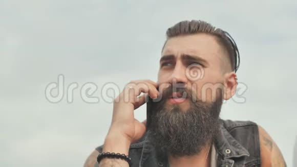 一个长着胡子的男人在电话里说话抽着烟视频的预览图