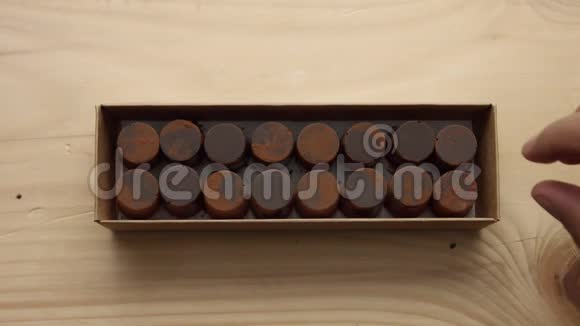 巧克力糖果盒的特写和一个男人手拿起其中一个视频的预览图