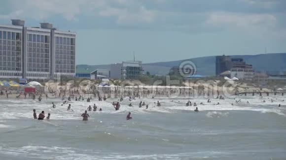 大海滩上巨浪人在后台游泳视频的预览图