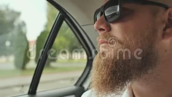 一个留着胡子的年轻人坐在汽车的后座上视频的预览图