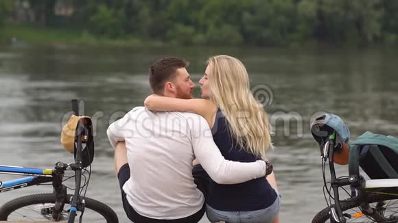 在河边骑自行车的幸福夫妇视频的预览图