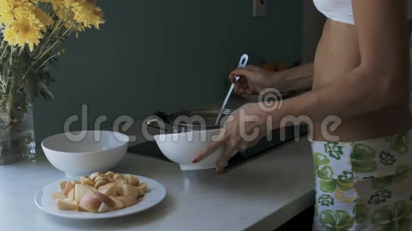 苗条的女人把热粥从锅里放进碗里视频的预览图