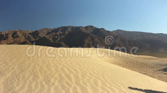 女人爬上沙丘视频的预览图