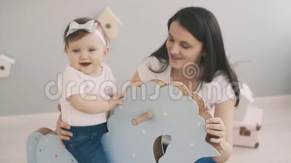 年轻的母女在室内慢动作玩玩具马视频的预览图