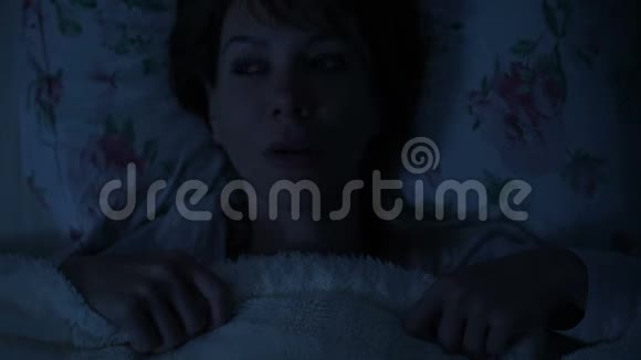一个女孩晚上躺在床上看着天花板睡不着从上面看视频的预览图