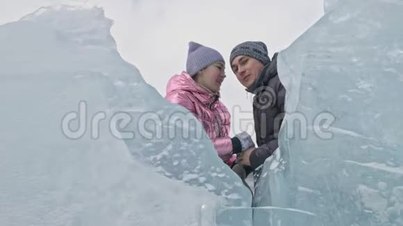 在冰封的湖面上年轻夫妇在冬天散步时玩得很开心爱情故事恋人们躲在冰后视频的预览图
