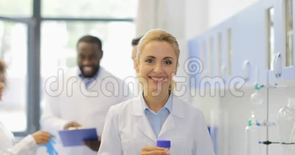 现代科学研究人员混合种族团队在实验室用化学药品分析瓶子快乐微笑视频的预览图