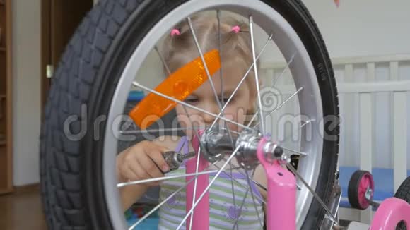 一个小女孩用螺丝刀坐在托儿所里自修自行车视频的预览图