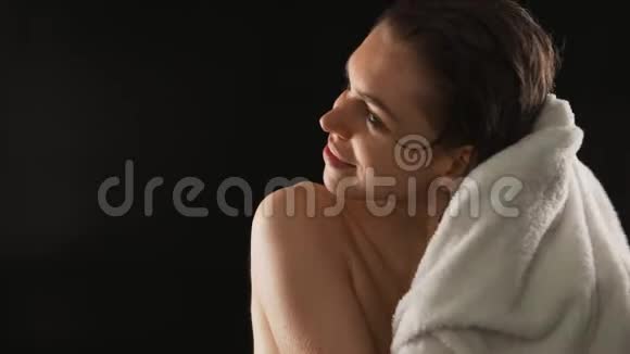 有魅力的年轻女士洗澡后用毛巾擦干头发慢慢地在黑色背景上隔离视频的预览图