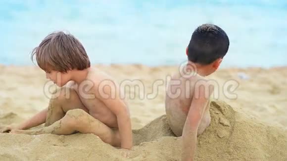 可爱的孩子埋在沙子里视频的预览图