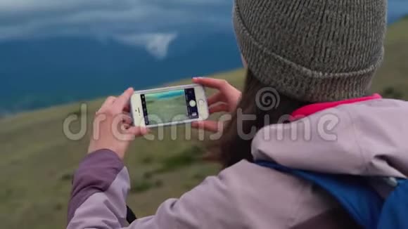 女士拍照智能手机分享照片景观自然背景享受度假旅行视频的预览图