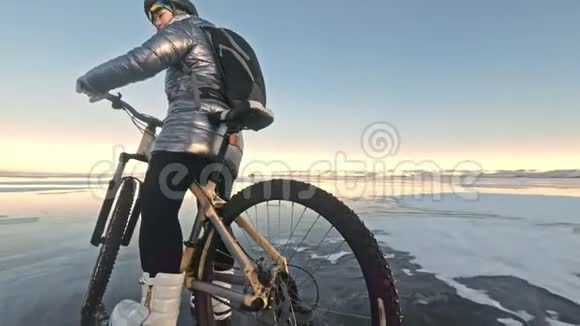 轮胎的视图拍摄60fps动作摄像头女人在冰上骑自行车冰的贝加尔湖轮胎视频的预览图