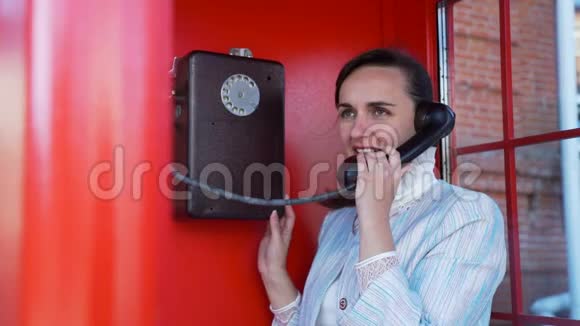 在红色电话亭打电话的女人视频的预览图