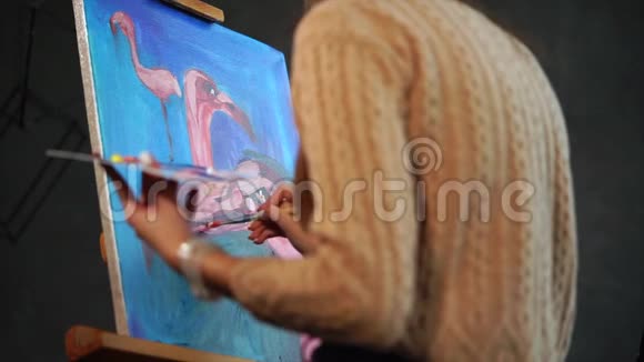 一个女人用不同的角度画火烈鸟她手里拿着一个调色板视频的预览图