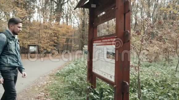 年轻的大胡子男子走在秋林与旅游背包秋季风格旅行生活方式视频的预览图