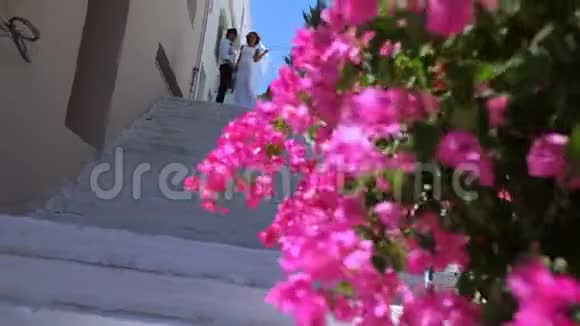 新娘和新郎站在街上的楼梯上结婚纪念日新婚夫妇的合影视频的预览图