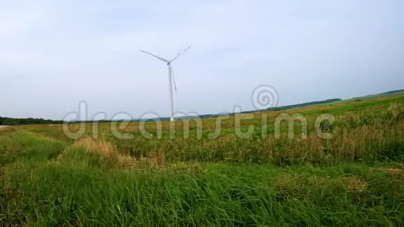 在蓝天背景下旋转风车螺旋桨的叶片风力发电纯绿色能源视频的预览图