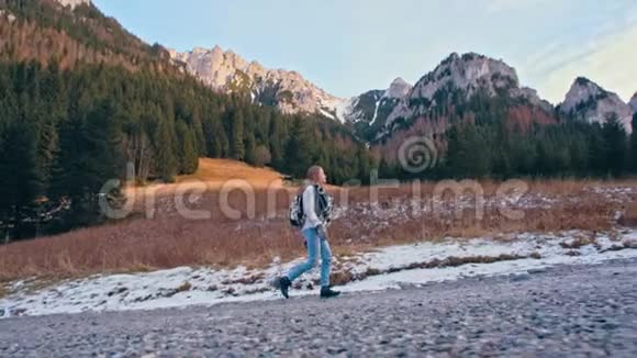 年轻苗条的女士走在美丽的山路上慢速运动视频的预览图