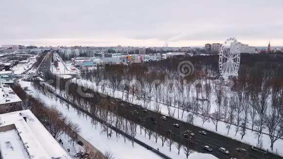 冬日里平静的城市景观顶景汽车在公路上行驶摩天轮在公园里行驶视频的预览图