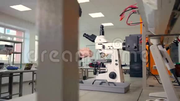 中学男生在显微镜下在学校实验室做生物学研究视频的预览图